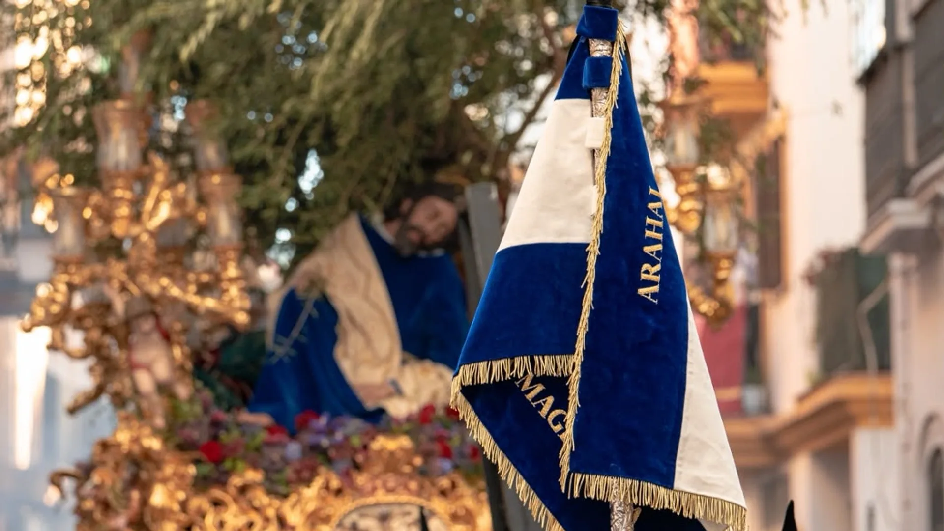 El banderín de Arahal de la agrupación, con el paso del Señor de la Oración en el Huerto al fondo.